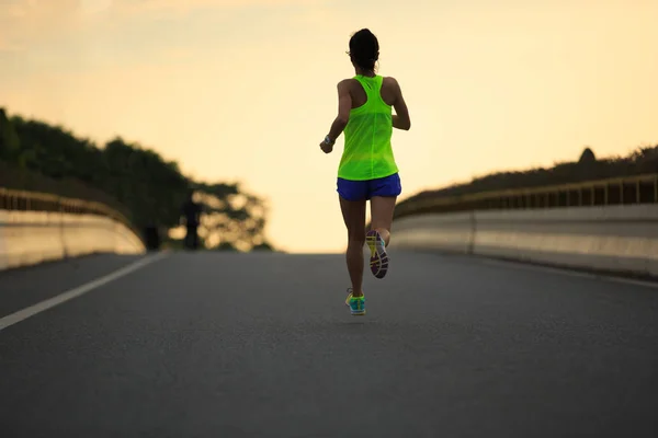 Mujer joven corriendo por la carretera —  Fotos de Stock
