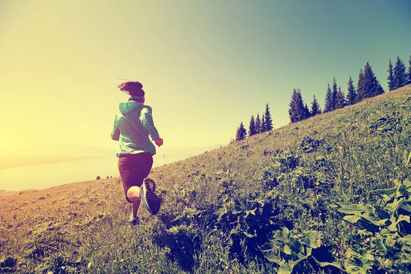 Mujer joven corriendo en la montaña — Foto de Stock