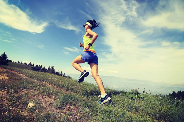 Mujer joven corriendo en la montaña — Foto de Stock