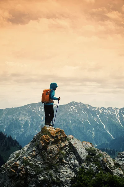 Mujer con mochila de pie en el pico —  Fotos de Stock