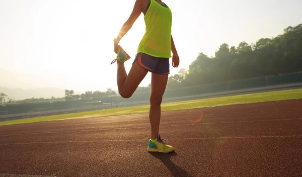 Jonge vrouw stretching benen — Stockfoto