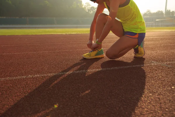 Vrouwelijke atleet gelijkmakende schoenveter — Stockfoto