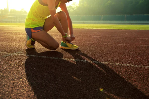 Vrouwelijke atleet gelijkmakende schoenveter — Stockfoto