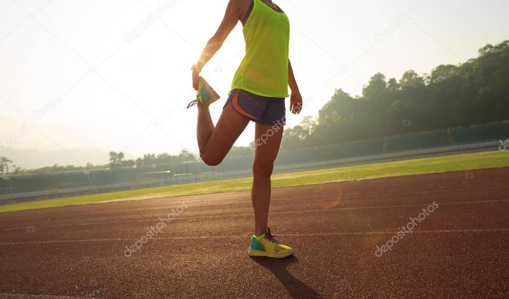 Young woman stretching legs 
