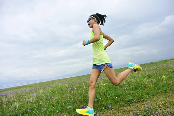 Young woman running on meadow — Stock Photo, Image