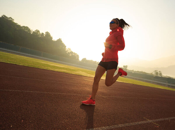 Young woman running on stadium  