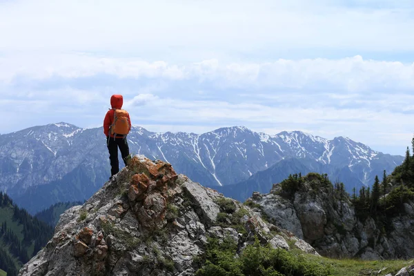 Žena s batoh stojící na vrcholu — Stock fotografie