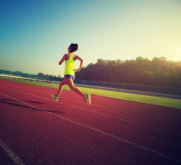 Mujer joven corriendo en el estadio — Foto de Stock