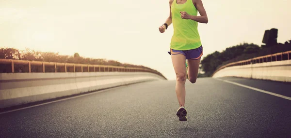 Mujer joven corriendo por la carretera — Foto de Stock