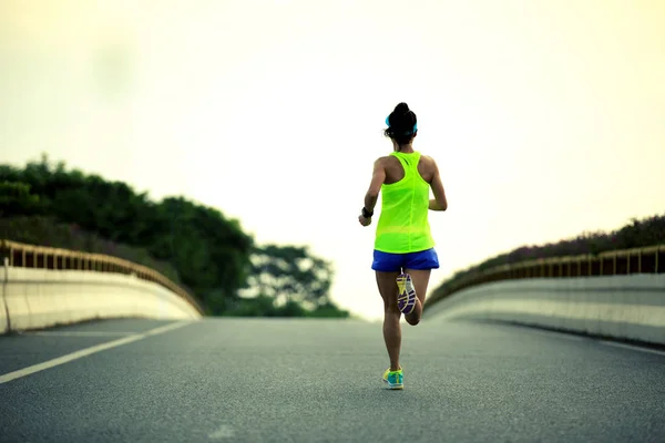 Jeune femme courant sur la route — Photo