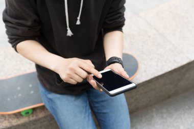 Genç kaykaycı Smartphone kullanarak