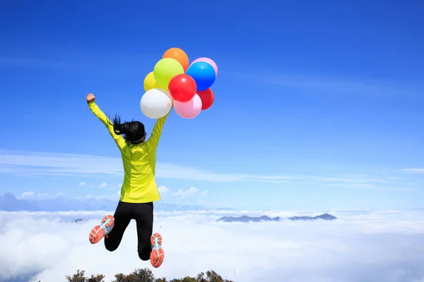 Junge Frau mit bunten Luftballons — Stockfoto