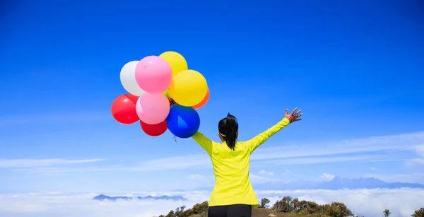 Junge Frau mit bunten Luftballons — Stockfoto