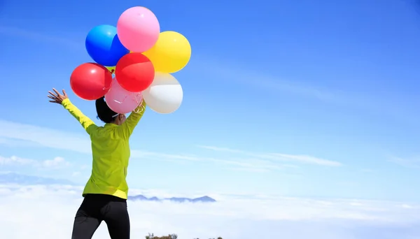 Junge Frau mit bunten Luftballons — Stockfoto