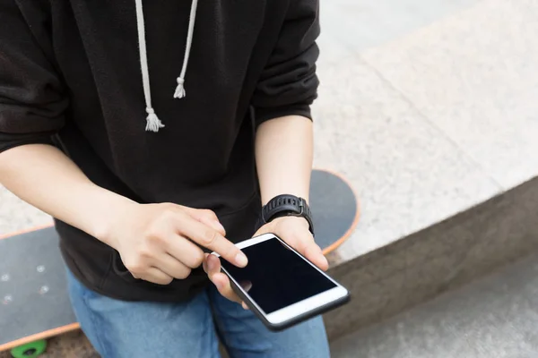 Mladý americký skateboardista pomocí smartphonu — Stock fotografie