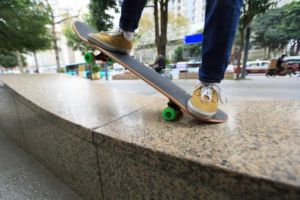 Skateboarder legs riding at city skatepark — стоковое фото