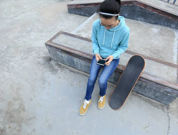 Jeune skateboarder en utilisant smartphone — Photo