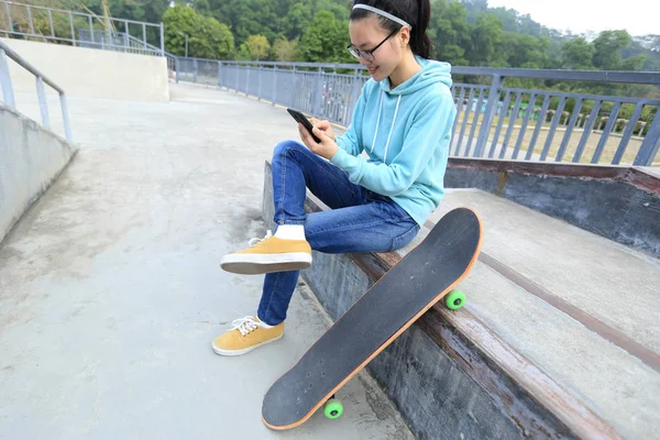 Jeune skateboarder en utilisant smartphone — Photo