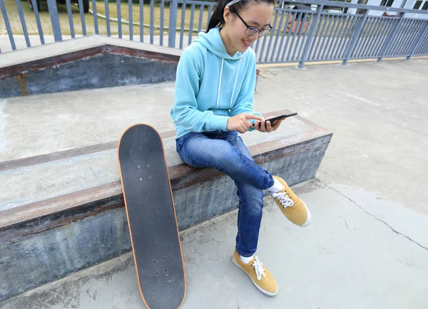 Νέοι skateboarder χρησιμοποιώντας smartphone — Φωτογραφία Αρχείου