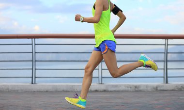  Genç kadın deniz kenarında koşuyor.