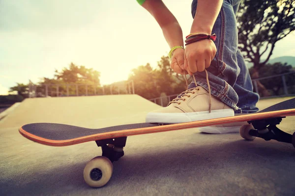 Jonge skateboarder gelijkmakende schoenveter — Stockfoto