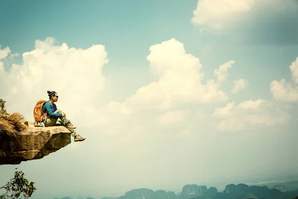 Young woman sitting on cliff — Stock Photo, Image