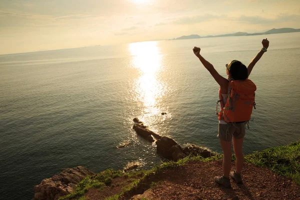 Mujer con mochila de pie en la montaña junto al mar — Foto de Stock