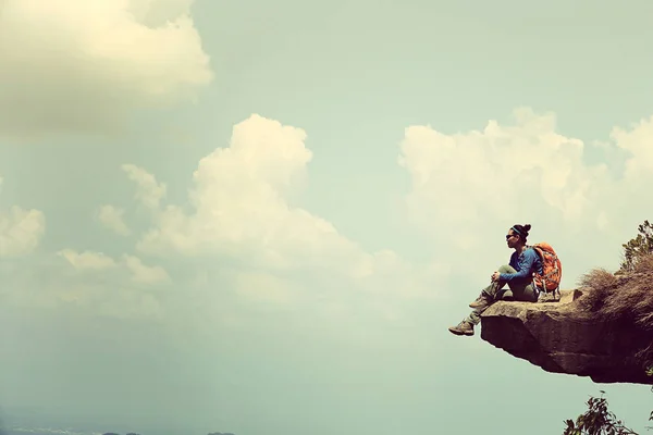 Vrouw zitten op mountain peak klif — Stockfoto