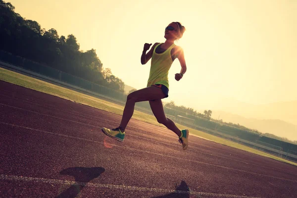 Femme qui court sur la piste du stade — Photo