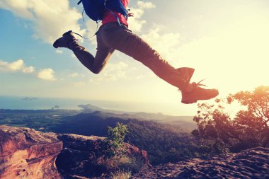 jumping over precipice between two rocky mountains clipart