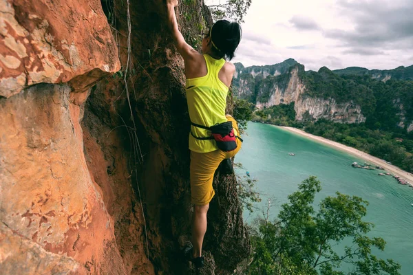 Donna arrampicata sulla scogliera sul mare — Foto Stock