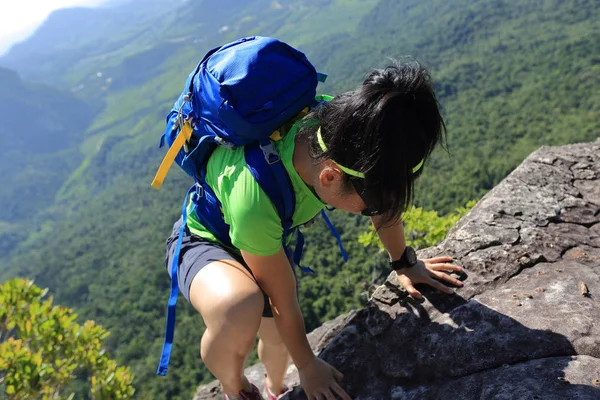 Молодая женщина, взбирающаяся на гору — стоковое фото