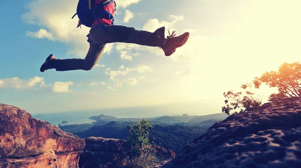 Mujer joven saltando en el pico de la montaña — Foto de Stock