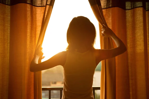 Young woman opening curtains — Stock Photo, Image