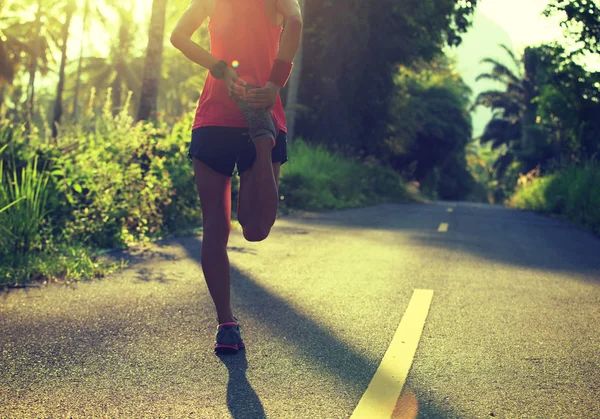 Молода жінка бігун розтягує ноги — стокове фото