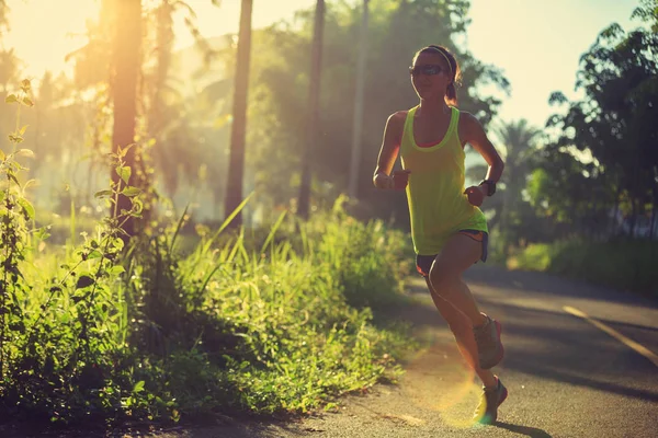 Mujer joven corriendo en el sendero del bosque —  Fotos de Stock