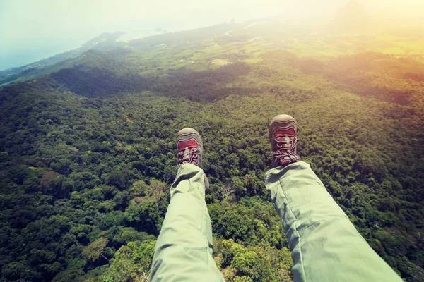 Pernas femininas no pico da montanha — Fotografia de Stock