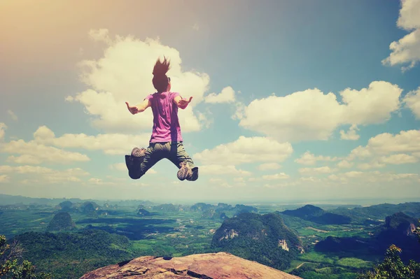 Young woman jumping on mountain peak — Stock Photo, Image