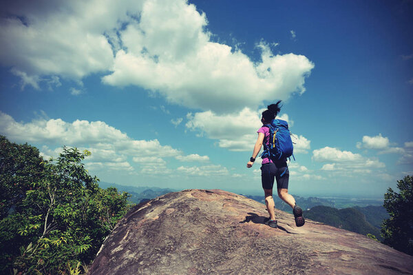 young woman running on mountain peak