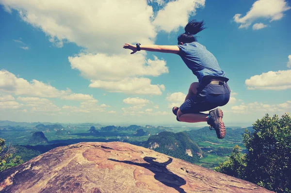 Mujer joven saltando en el pico de la montaña — Foto de Stock