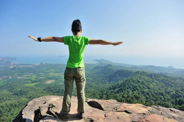 Mujer joven de pie en la cima de la montaña — Foto de Stock