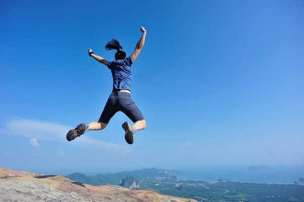 Kvinna hoppa på bergstopp — Stockfoto