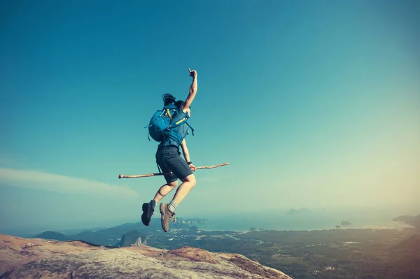 Mujer saltando en pico de montaña — Foto de Stock