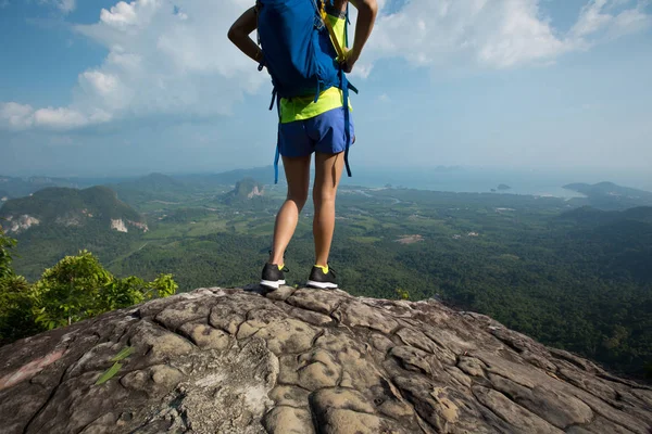 Mulher com mochila em pé no pico da montanha — Fotografia de Stock