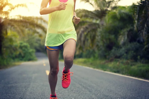 Mujer joven corriendo por sendero forestal —  Fotos de Stock