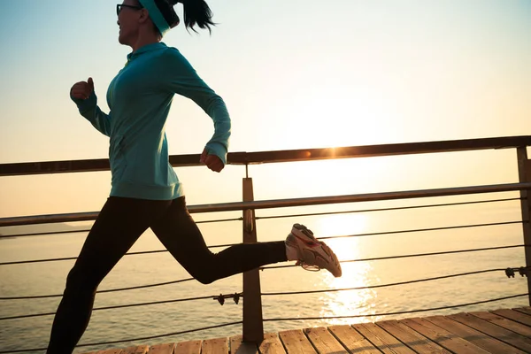Sporty young woman running at seaside — Stock Photo, Image