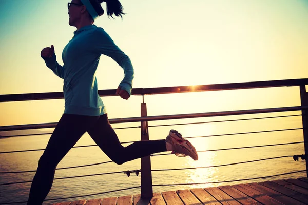 Sportliche junge Frau läuft am Meer — Stockfoto