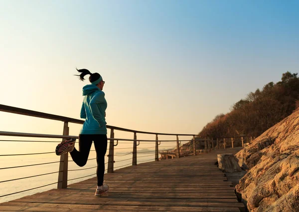 Sporty young woman running at seaside — Stock Photo, Image