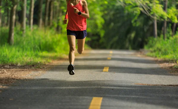 Young woman running at forest trail — Stock Photo, Image