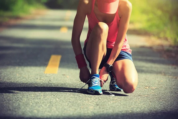 Mujer joven atando cordones — Foto de Stock